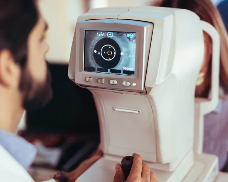 Eye doctor using diagnostic equipment on patient