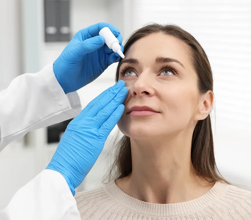 Doctor giving eye drops to patient