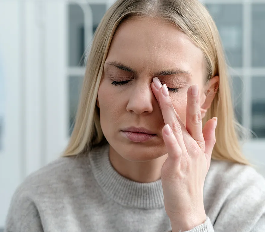 young woman touching her eye in pain