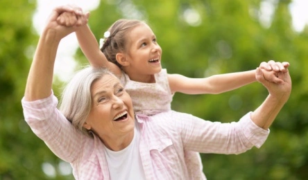 mature woman playing with granddaughter outside