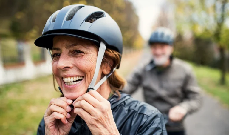 Mature woman strapping on bike helmet