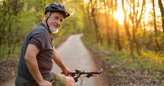 Mature man riding bike on nature path