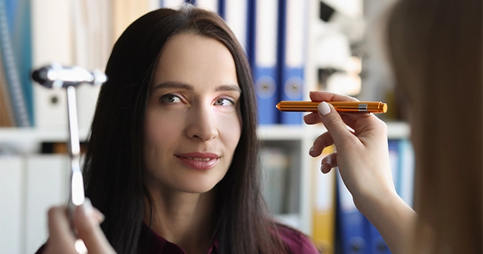 Patient having her eye reflexes checked