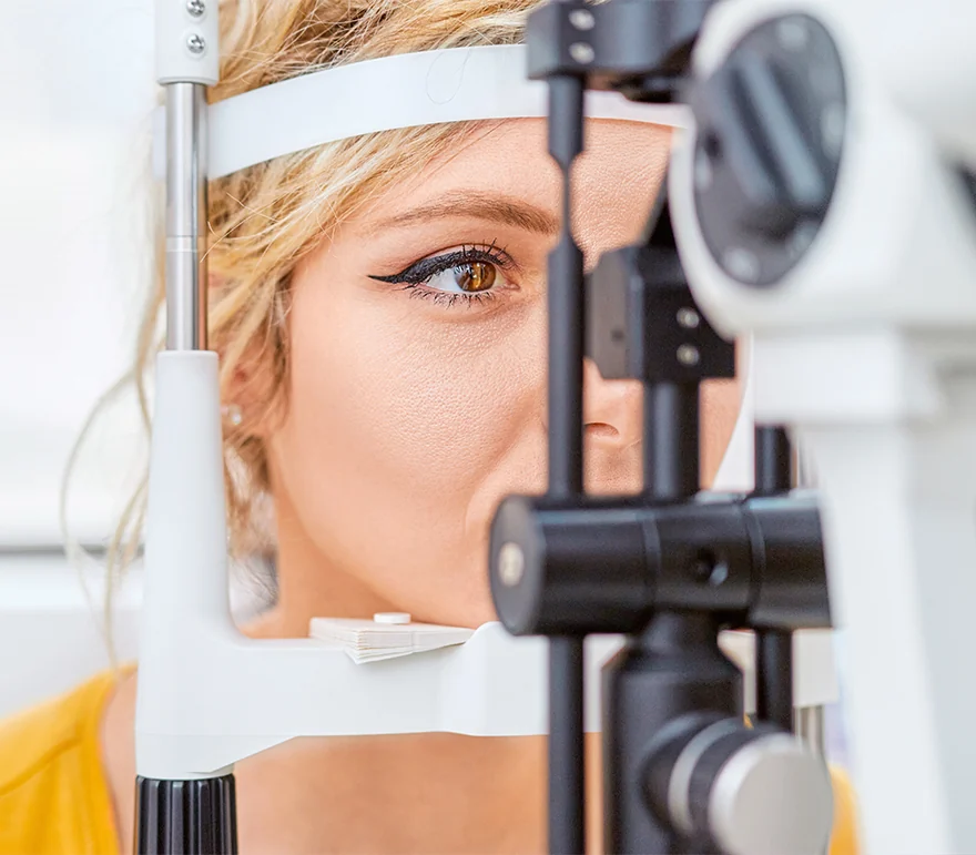 Young woman checking eyesight with slit lamp