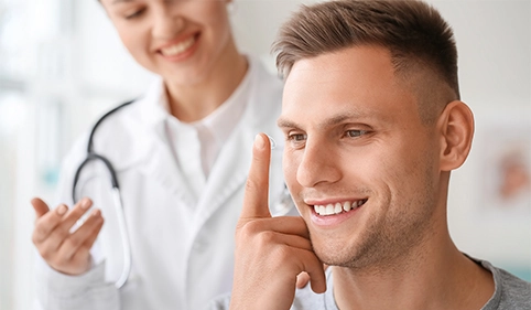 Male patient putting in contact lens at ophthalmologist