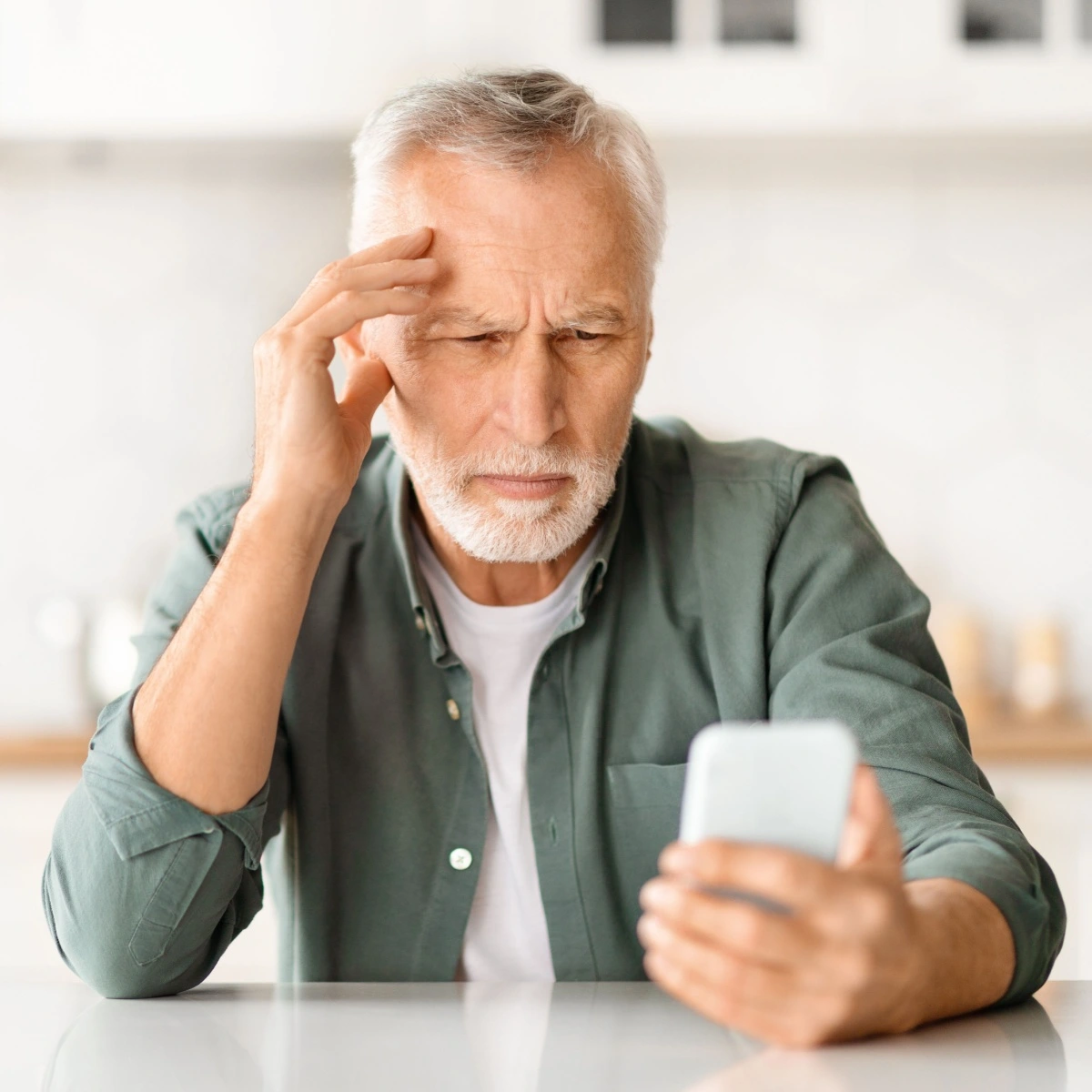 man straining to read text on his phone