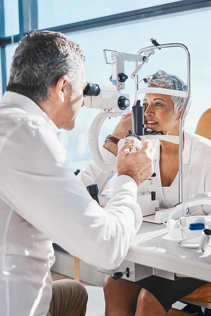 eye doctor examining retina of senior woman