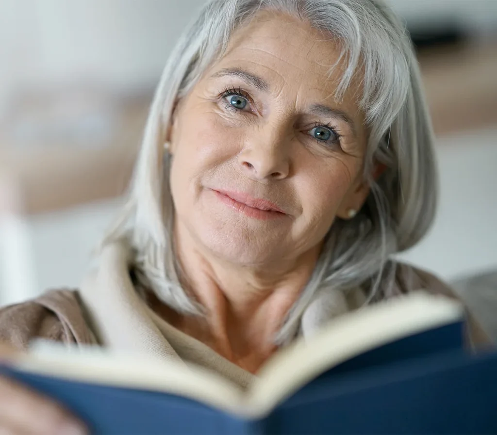 Senior woman looking up from her book