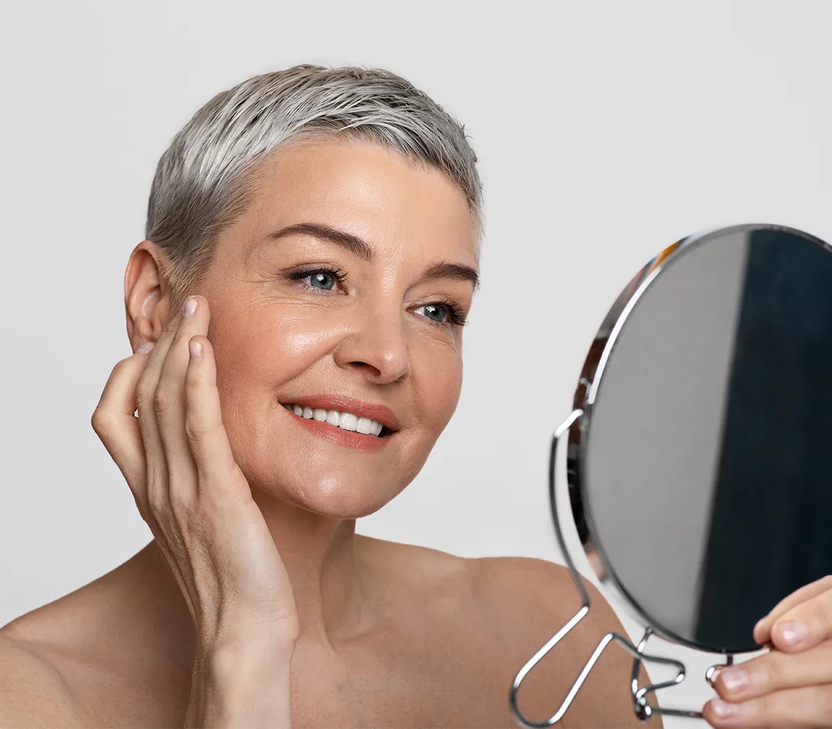senior woman looking into the mirror after restylane injections