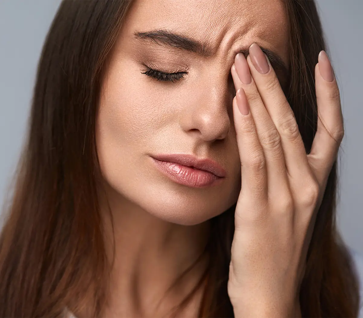 young woman rubbing her eye